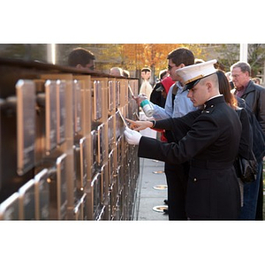 A uniformed man looks at a plaque on the Veterans Memorial at the dedication ceremony