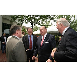 Richard Egan converses with men at the Veterans Memorial groundbreaking ceremony