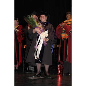 Faculty member poses with flowers at School of Nursing convocation