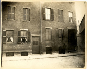 Exterior view of a building, with a woman leaning out of a window, Lindall Place, Boston, Mass., 1911