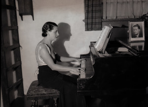 Mrs. Carl Miller (?) playing the piano