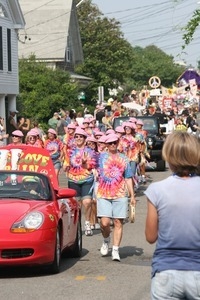 Paraders in tie-dyed shirts and pink hats : Provincetown Carnival parade