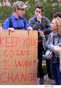 Occupy Wall Street: journalist interviewing demonstrator holding a sign reading, 'keep your coins, I want change'