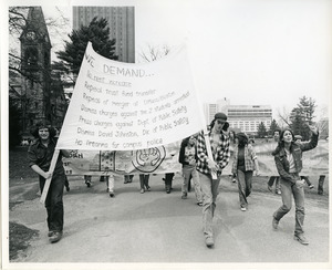 Board of Trustees fee increase demonstration: Charles Bagli (l) and protestors with sign and banner marching from the Student Union to the Whitmore Administration Building