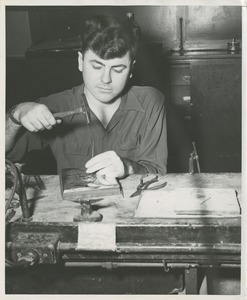 ICD trainee William DeMarshe shapes the gold presidential seal on the 1953 President's Trophy