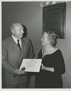 Unidentified man handing Colonel Smith's citation for distinguished service to an unidentified woman