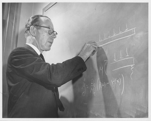 Dr. Merit P. White writing on the blackboard in a classroom