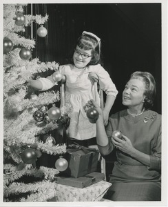 Woman and young girl decorating Christmas tree