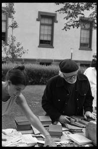 Thomas C. Crowe and woman looking over books at a tag sale at the Unitarian Society, Northampton