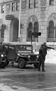 Unidentified officer directing Military Police vehicle in front of Boston Police Headquarters on Berkeley Street