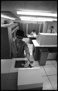 Computer room scene: woman operating a Hollerith card machine, part of a Honeywell Model 400 mainframe set up