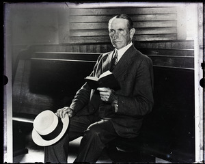 Col. John Coolidge, seated in a pew, reading a Bible