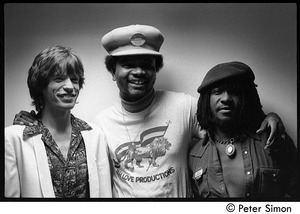 Mick Jagger, unidentified, and Sly Dunbar posed backstage, during an appearance with Peter Tosh on Saturday Night Live