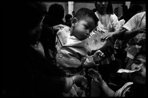 Cambodian New Year's celebration: musician taking money his teeth from mother and child