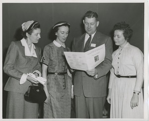 Three women and one man reading a pamphlet