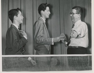 Two young men with unidentified man at project diadem ping pong tournament