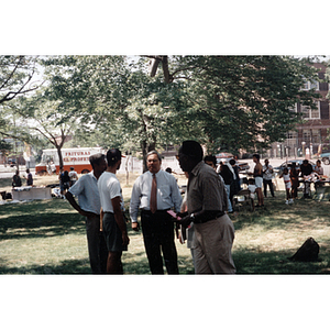 Mayor Thomas Menino stands among a small group of men at a park event