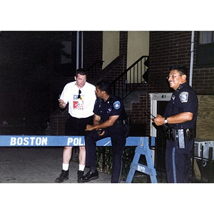 Two uniformed policeman and a man in a Festival Betances t-shirt at Festival Betances 1999.