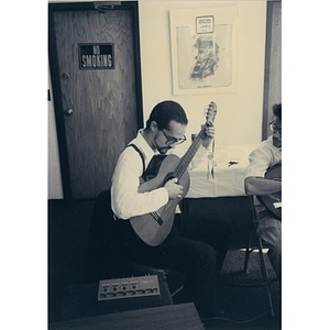 Man playing a guitar in the Inquilinos Boricuas en Acción offices.