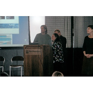 John Prendergast, left, and Elizabeth Wyka, a Holocaust Awareness Committee member, standing at a podium.