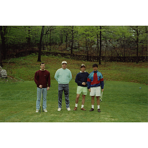 A four-man golf team standing on the golf course at a Boys & Girls Club Golf Tournament