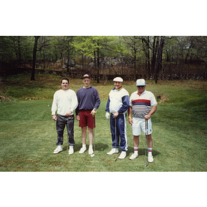 A four-man golf team posing with their clubs at a Boys and Girls Club Golf Tournament