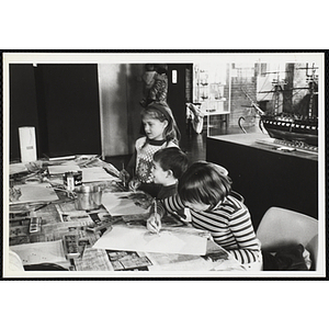 A girl and two boys working on projects for their arts and crafts class at the Boys' Clubs of Boston