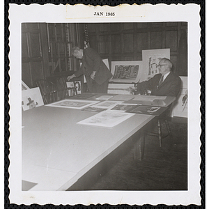 Two Art Selection Committee members Richard H. Bassett, at left, and an unidentified man select paintings for the Boys' Clubs of Boston Fine Arts Exhibit at the Amory Coolidge Gallery, Museum of Science