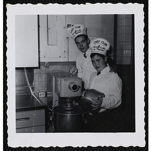 Two members of the Tom Pappas Chefs' Club pose next to an industrial mixer