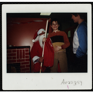 Santa Claus presents a boy with a hockey stick as another boy looks on