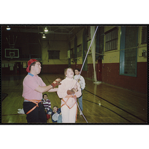 A girl holds a safety rope in a gymnasium