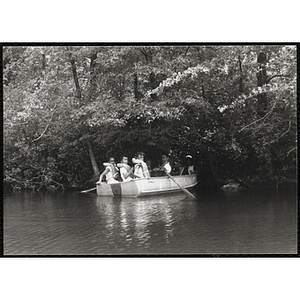 Five youth and a supervisor pose for the camera in a rowboat