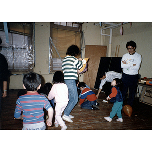 Guests pick up candy from a piñata during the Chinese Progressive Association's children's party