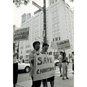 Demonstrators stand on the corner of Washington Street and Oak Street in Chinatown protesting Liberty Place project