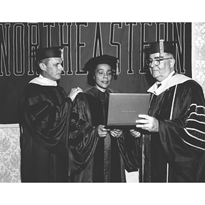 Coretta Scott King receives her honorary degree from President Knowles with escort Donald B. Guy