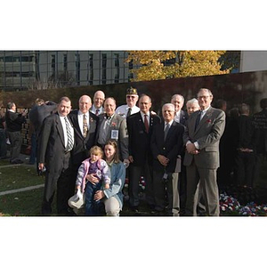 Several people pose in front of the Veterans Memorial at the dedication ceremony