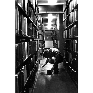 A student searches for a book in the Dodge Library stacks