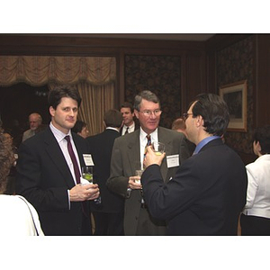 Three men with drinks at the gala dinner for John Hatsopoulos