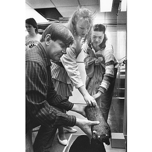 A biology graduate student brings out a specimen for high school students visiting campus during Science and Technology Day