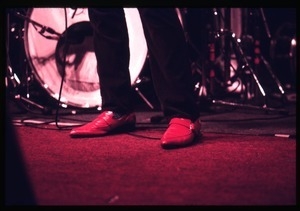 Elvis Costello and the Attractions in concert: close-up of Costello's red shoes