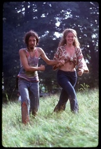 Hippie couple in tie-dye and Indian print, cavorting through the fields, Woodstock Festival