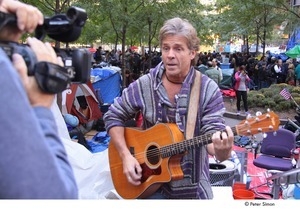 Occupy Wall Street: man playing guitar and singing in front of video camera