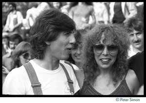 Graham Nash in overalls standing with Joni Mitchell at the No Nukes protest and concert