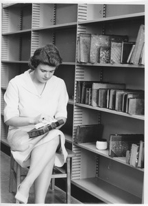 Woman cleaning a book in the Goodell addition