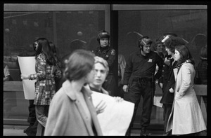 Police watch as antiwar demonstrators picket in front of the John F. Kennedy Federal Building