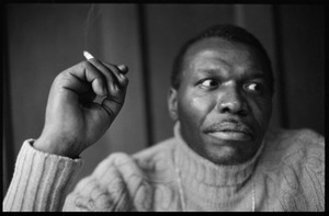 Elvin Jones: half-length portrait of jazz musician, seated, smoking a cigarette