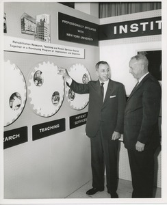 Two unidentified men in front of an ICD exhibit