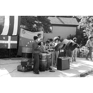Hispanic American band, consisting of boys and young men, plays music at a Latino street festival