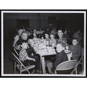 Men and boys sit at a table during a Dad's Club banquet