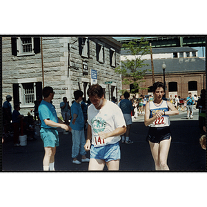 A man and a woman cross the finish line of the Battle of Bunker Hill Road Race